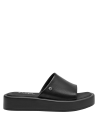 Moderna sandalia de cuero negro con suela de plataforma media y estilo chic minimalista.
