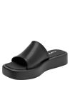Sandalia de cuero negro minimalista para mujer con banda ancha y adorno metálico discreto.
