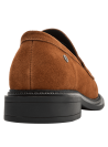 Mocasín de cuero café para mujer con textura de gamuza y adorno metálico en la parte superior.