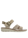 Sandalia versátil de cuero beige, estilo casual con detalles florales y hebilla dorada para eventos relajados.