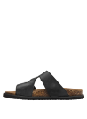Elegante sandalia de cuero negro, estilo casual, con textura lisa y hebillas metálicas.