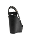 Elegante sandalia de cuero negro con suela que imita la textura de madera.