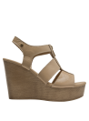 Sandalia versátil de cuero beige, perfecta para looks casuales y semi-formales.