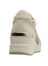 zapatilla de mujer en tonos crema y dorado, combinando texturas modernas y estilo chic.