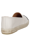 Elegante alpargata de mujer en cuero blanco con contraste negro, estilo minimalista.