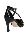 calzado femenino negro de cuero charol con detalles metálicos dorados y diseño elegante de punta aguda.