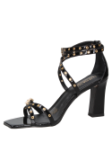Sandalia negra de cuero para mujer con tachas doradas y hebillas cuadradas, estilo glam rock.
