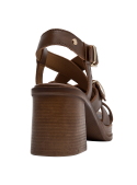 Tacón bloque de cuero café que brinda altura y estabilidad en días cálidos.