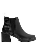 Botín urbano de cuero negro para mujer, ideal para un look audaz con vestido fluido.