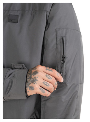 Bolsillos laterales de la parka gris, prácticos y cómodos para uso diario.